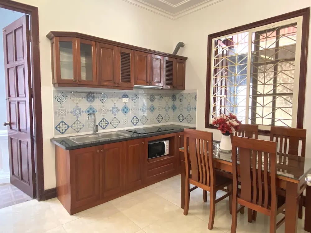 Cozy kitchenette with stove, fridge, and utensils, perfect for home cooking.