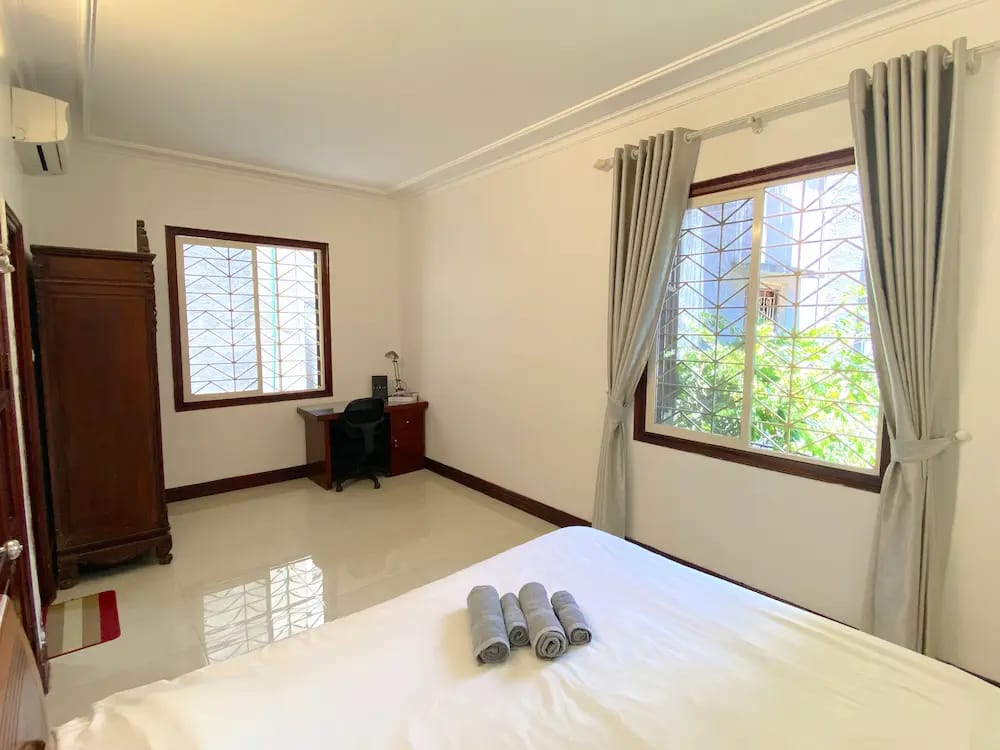 Modern, airy bedroom with large windows and stylish décor.