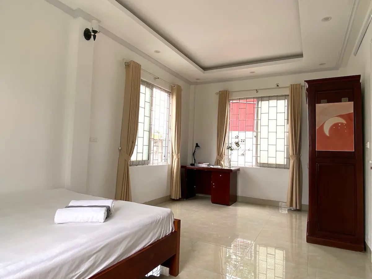 Modern, airy bedroom with large windows and stylish décor.