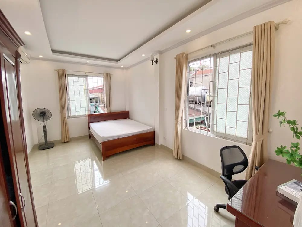 Modern, airy bedroom with large windows and stylish décor.